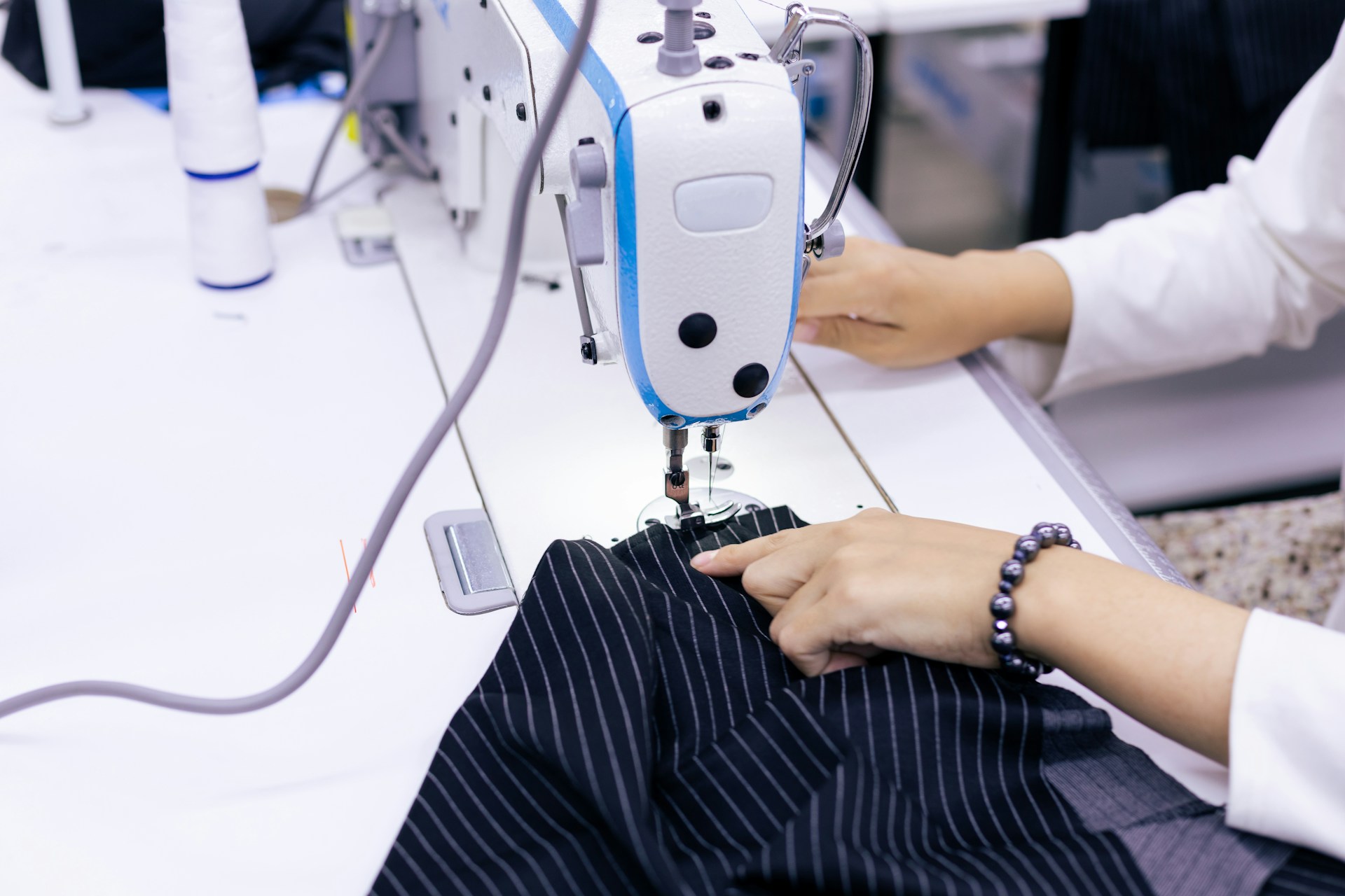 A tailor working on same day alterations in a professional shop